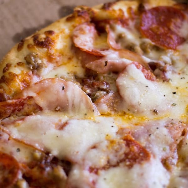 Close-up of a Venice Pizza with melted cheese, pepperoni, and sausage on a crispy crust.